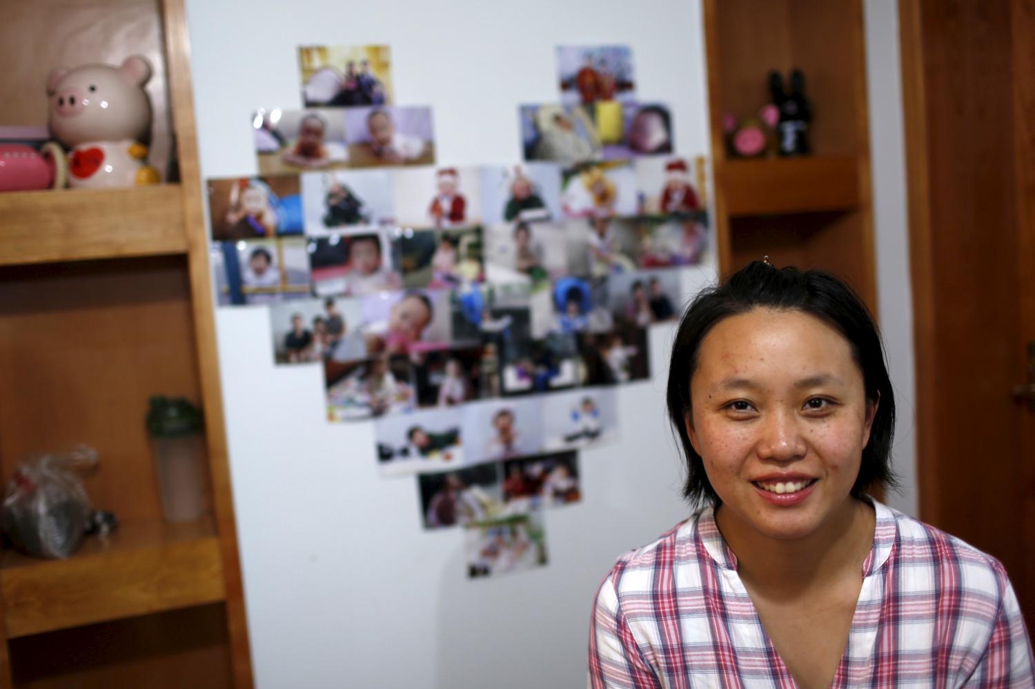 Zhang Yingyi, a 30-year-old administrative assistant and a mother of a three-year-old girl, smiles as she poses for a photograph at her home in Shanghai, China,