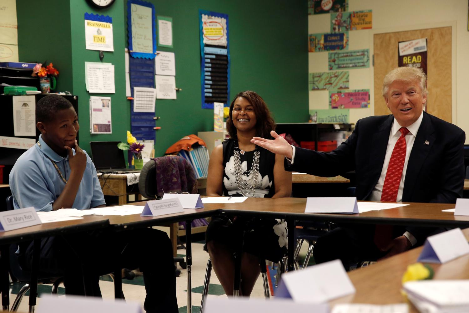 Republican presidential nominee Donald Trump gestures as he sits with 12 year old student Egunjobi Songofunmi and Head of School Debroah Mays during a campaign visit to the Cleveland Arts and Social Sciences Academy in Cleveland