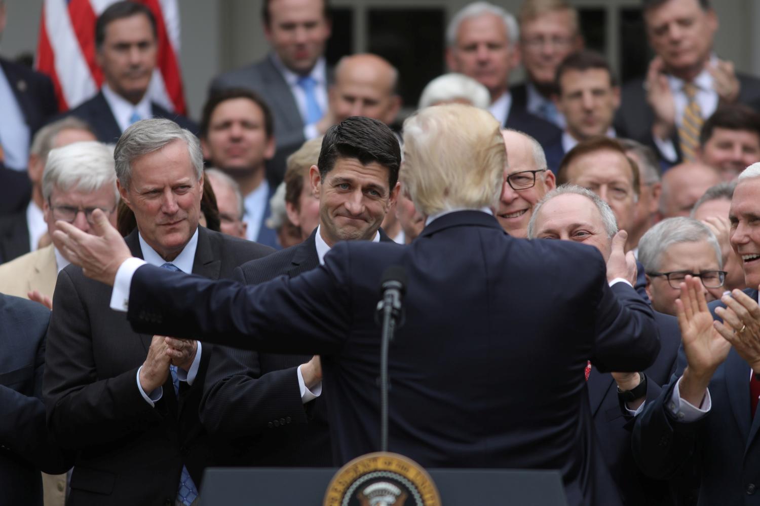 U.S. President Donald Trump (C) turns to House Speaker Paul Ryan (3rdL) as he gathers with Congressional Republicans in the Rose Garden of the White House after the House of Representatives approved the American Healthcare Act, to repeal major parts of Obamacare and replace it with the Republican healthcare plan