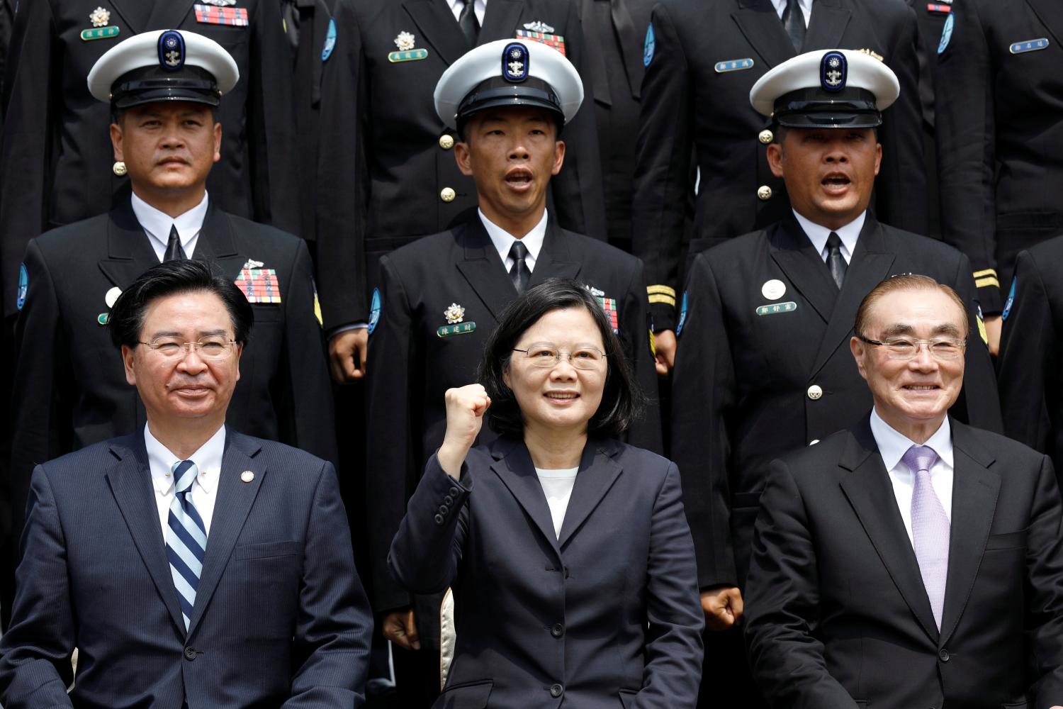 Taiwan President Tsai Ing-wen and Defence Minister Feng Shih-kuan (front row R) react as they take a group photo with navy personnel after visiting a navy base in Kaohsiung, Taiwan