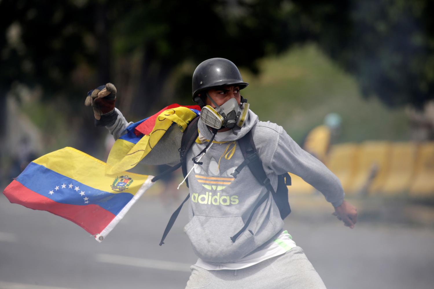 A demonstrator clashes with riot security forces while rallying against Venezuela's President Nicolas Maduro in Caracas, Venezuela, May 31, 2017. REUTERS/Marco Bello - RTX38FMC