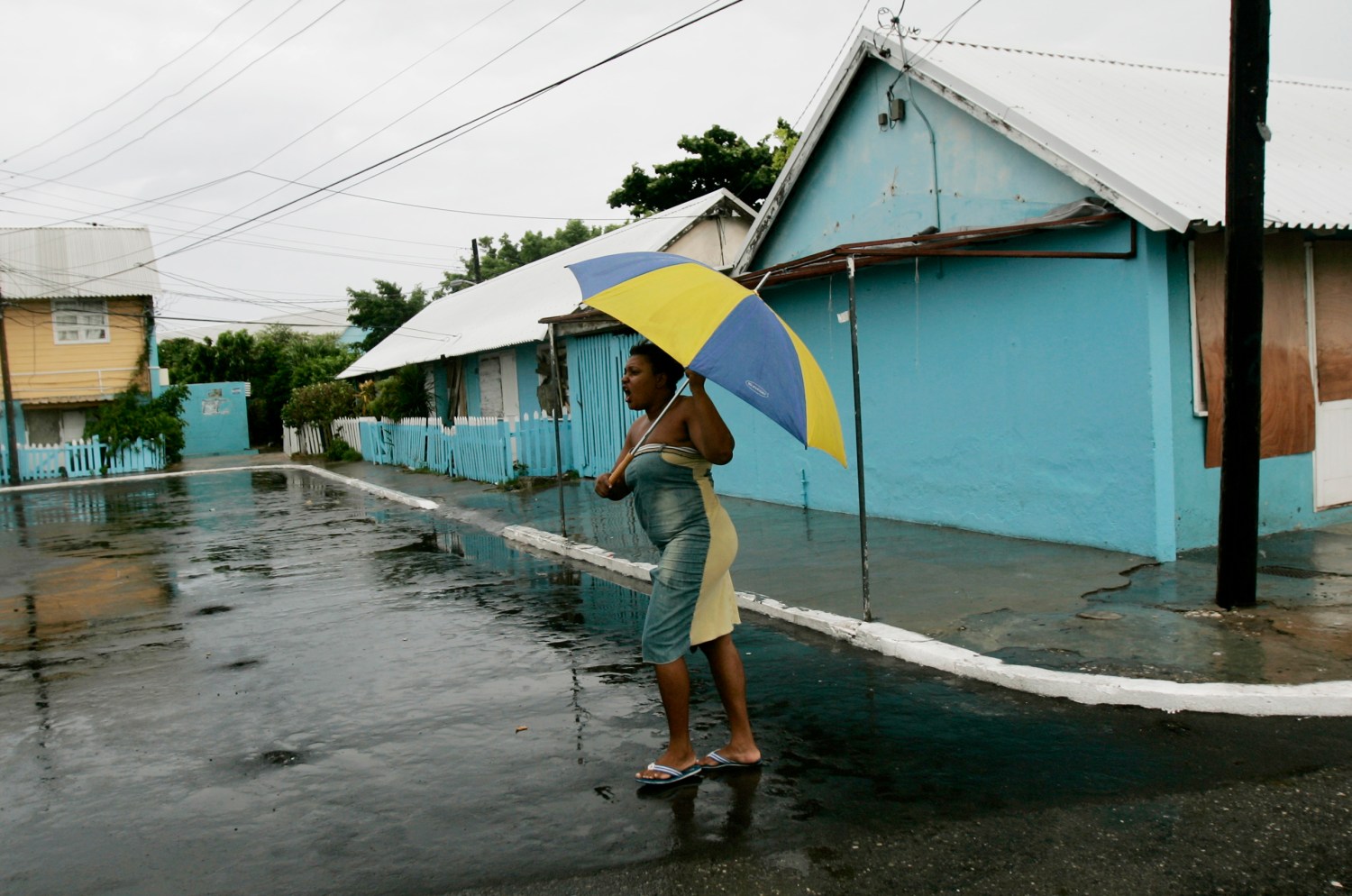 A resident of Port Royal walks in an empty street before the arrival of Hurricane Dean in Kingston, Jamacia August 19, 2007.Hurricane Dean bore down on Jamaica and the Cayman Islands on Sunday and threatened to pound Mexico's Yucatan Peninsula as a rare Category 5 storm. REUTERS/Carlos Barria (JAMAICA) - RTR1SWNT