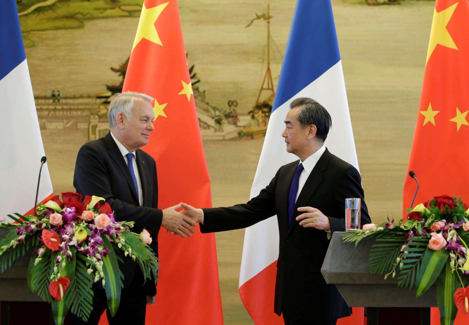 China's Foreign Minister Wang Yi shakes hands with French Foreign Minister Jean-Marc Ayrault in Beijing