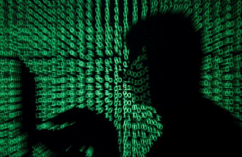 A man holds a laptop computer as cyber code is projected on him in this illustration picture taken on May 13, 2017. Capitalizing on spying tools believed to have been developed by the U.S. National Security Agency, hackers staged a cyber assault with a self-spreading malware that has infected tens of thousands of computers in nearly 100 countries. REUTERS/Kacper Pempel/Illustration - RTX35OS0