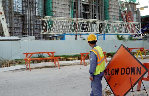 A worker stands outside the construction site.