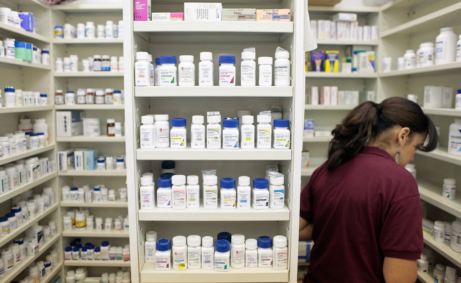 A pharmacy employee looks for medication.