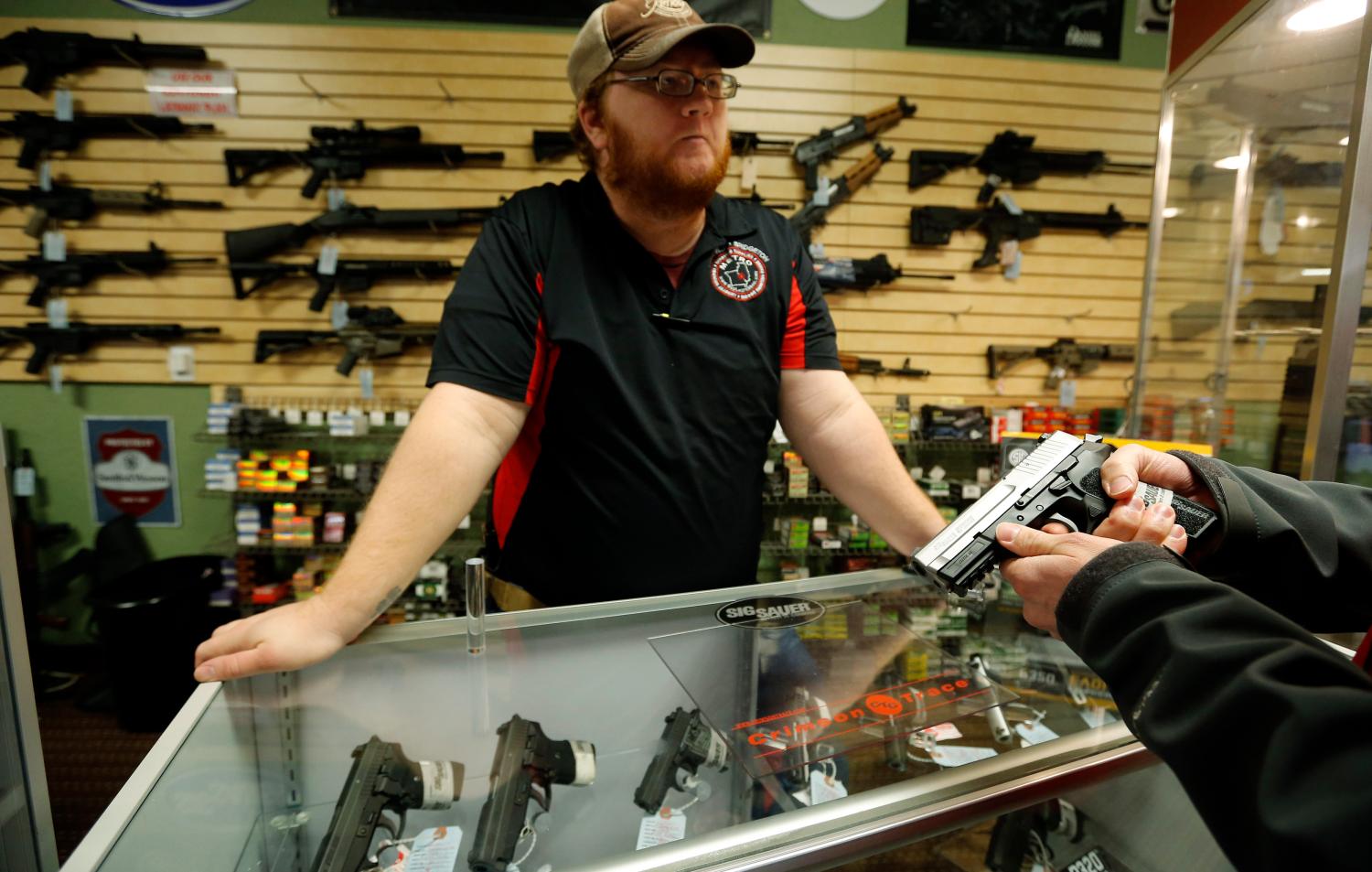 Metro Shooting Supplies' employee Chris Cox speaks to a customer.