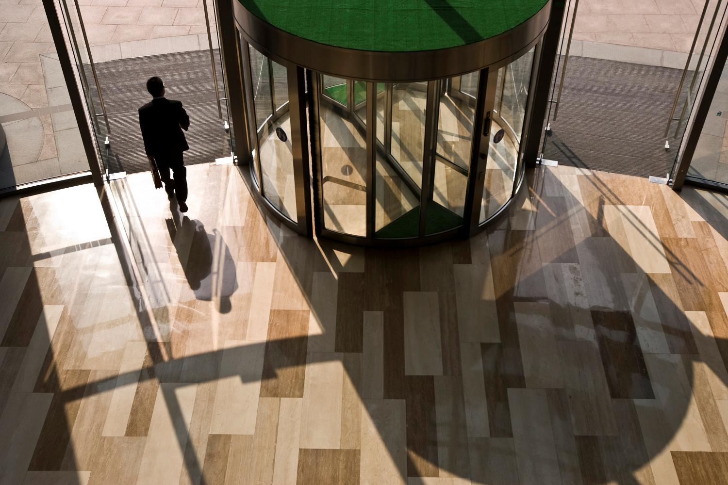 A businessman walks out of the headquarter building.