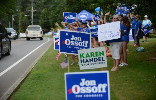 Supporters for Georgia 6th Congressional District Democratic candidate Jon Ossoff rally and wave at passing cars amid signs for Republican candidate Karen Handel outside St Mary's Orthodox Church, Handel's polling place in Roswell, Georgia, U.S., June 20, 2017. REUTERS/Bita Honarvar - RTS17VZQ