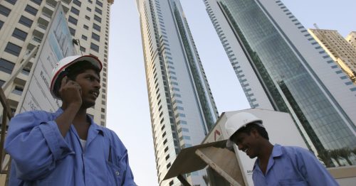 A foreign worker uses his mobile phone at a construction site in Dubai, United Arab Emirates, November 13, 2006. The United Arab Emirates should crack down on employers abusing the rights of migrant workers who are key to the Gulf Arab state's construction boom, Human Rights Watch said in a report on Sunday. REUTERS/Ahmed Jadallah (UNITED ARAB EMIRATES) - RTR1JAWF