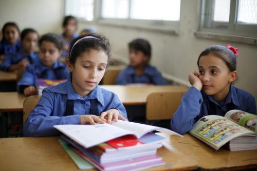 Refugee schoolchildren receive their new books on the first day of the new school year at one of the UNRWA schools at a Palestinian refugee camp al Wehdat in Amman