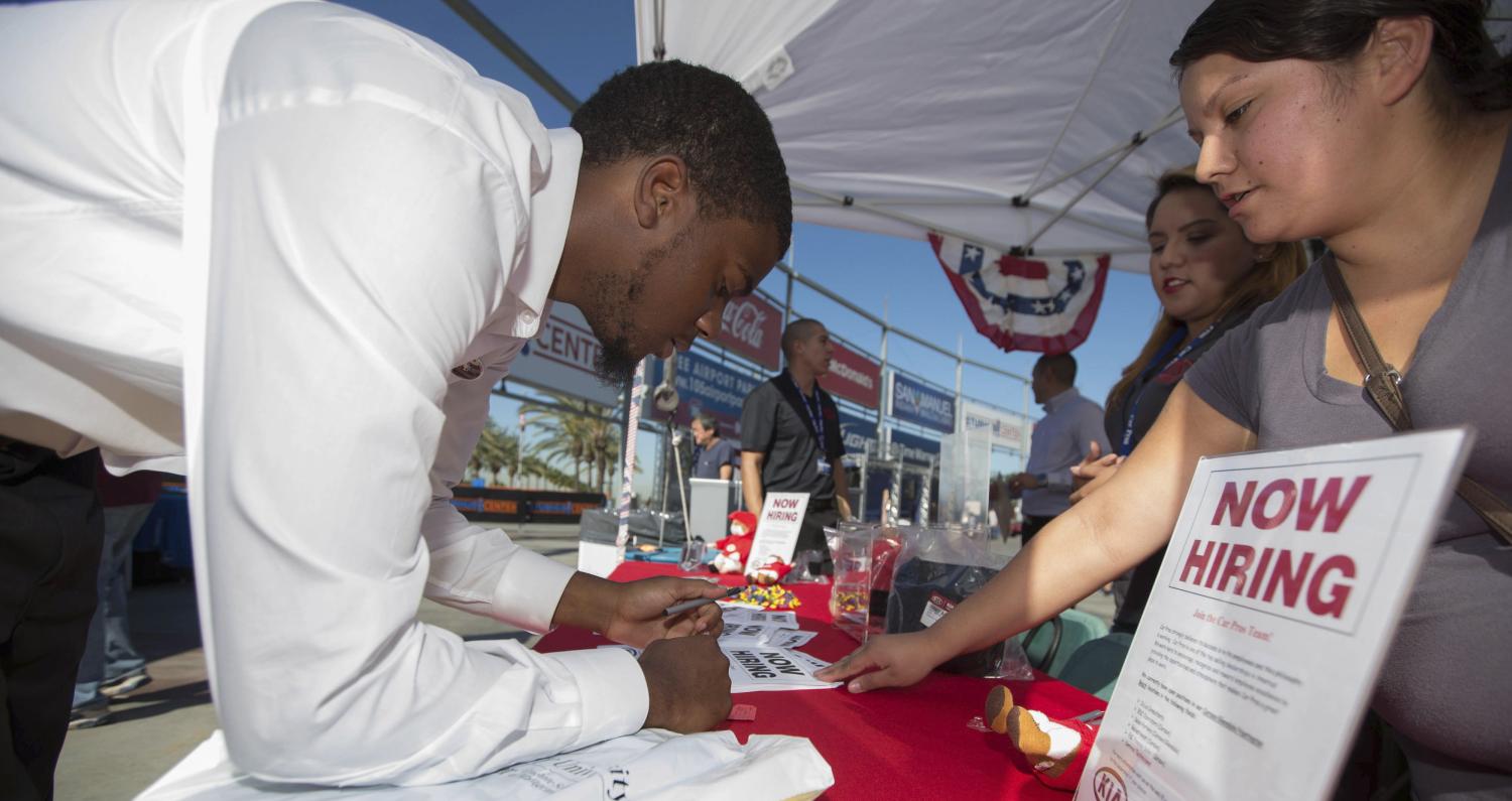 A man fills out a form at a booth at a military veterans' job fair in Carson, California October 3, 2014. U.S. employers ramped up hiring in September and the jobless rate fell to a six-year low, bolstering bets the Federal Reserve will hike interest rates in mid-2015. Friday's report on employment is the most significant gauge of the economy's health ahead of Nov. 4 congressional elections. REUTERS/Lucy Nicholson (UNITED STATES - Tags: BUSINESS EMPLOYMENT MILITARY) - RTR48UUW