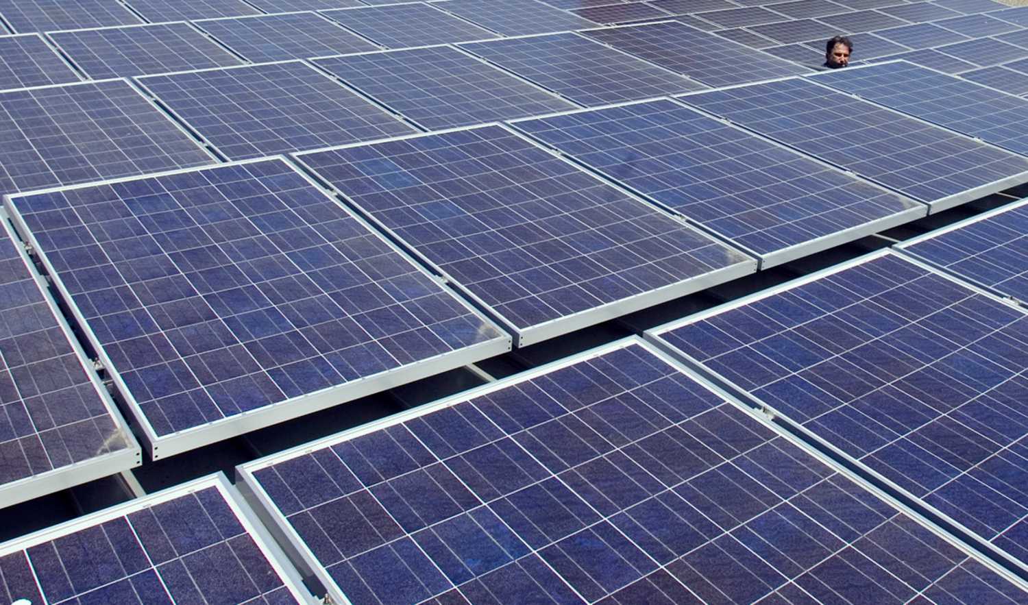 A man views solar panels on a roof at Google