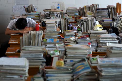 A student takes a nap on a desk during his lunch break in a classroom in Hefei