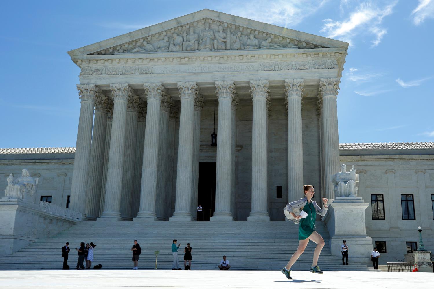 A news assistant runs out after the U.S. Supreme Court granted parts of the Trump administration's emergency request to put his travel ban into effect immediately while the legal battle continues, in Washington