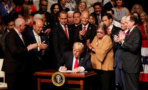 U.S. President Donald Trump signs a document after announcing his Cuba policy at the Manuel Artime Theater in the Little Havana neighborhood in Miami, Florida, U.S. June 16, 2017. REUTERS/Joe Skipper - RTS17F5J