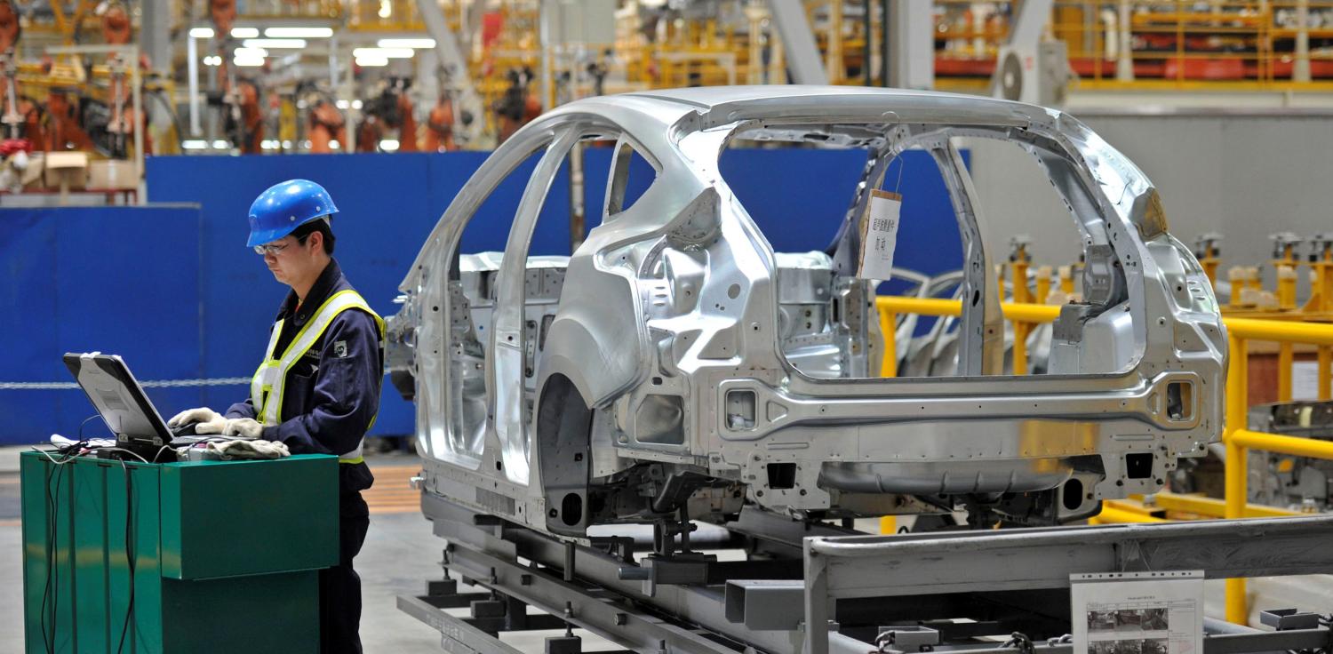 An employee uses a laptop next to a car body at an assembly line at a Ford manufacturing plant in Chongqing municipality April 20, 2012. REUTERS/Stringer CHINA OUT. NO COMMERCIAL OR EDITORIAL SALES IN CHINA - RTS17Y7U