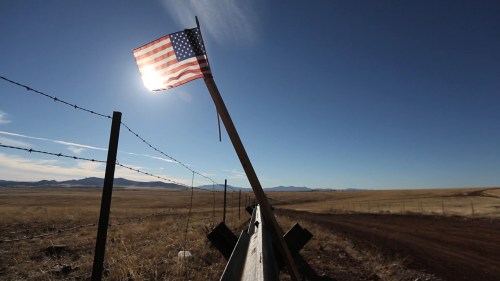 fencing and a U.S. flag along the U.S.-Mexico border