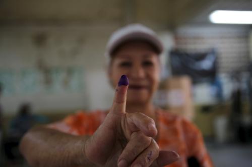 A women shows her ink-stained finger after casting her vote during a legislative election, in Caracas December 6, 2015. REUTERS/Nacho Doce TPX IMAGES OF THE DAY - RTX1XEL0