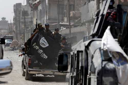 Iraqi Federal Police members hold an Islamic State flag which they pulled down during fighting between Iraqi forces and Islamic State militants in the Old City of Mosul