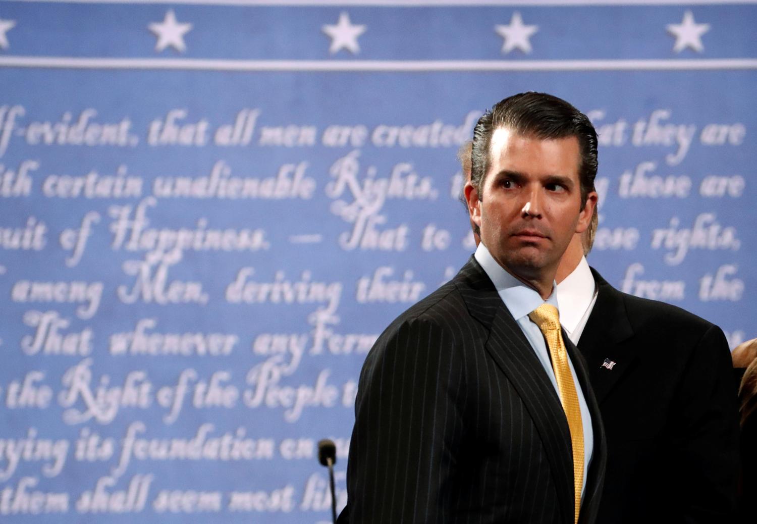 Donald Trump Jr. stands onstage with his father