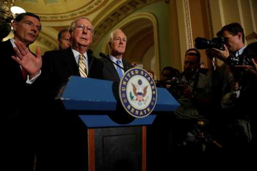 Senate Majority Leader Mitch McConnell, accompanied by Senator John Cornyn (R-TX) and Senator John Barrasso (R-WY), speaks with reporters following the successful vote to open debate on a health care bill on Capitol Hill in Washington, U.S., July 25, 2017. REUTERS/Aaron P. Bernstein - RTX3CVWW