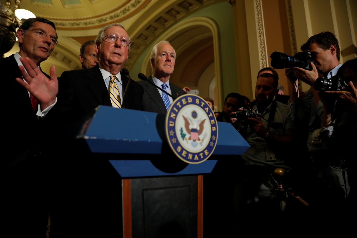 Senate Majority Leader Mitch McConnell, accompanied by Senator John Cornyn (R-TX) and Senator John Barrasso (R-WY), speaks with reporters following the successful vote to open debate on a health care bill on Capitol Hill in Washington, U.S., July 25, 2017. REUTERS/Aaron P. Bernstein - RTX3CVWW