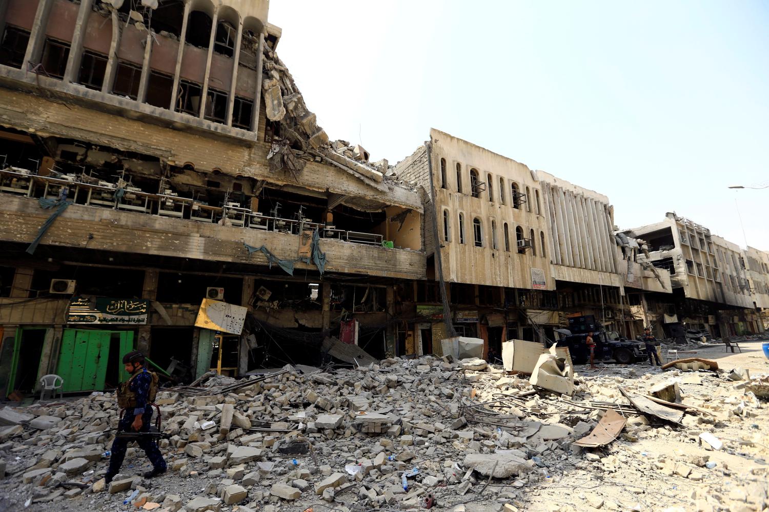 A member of Iraqi federal police walks next to destroyed buildings in the Old City of Mosul, Iraq July 23, 2017. REUTERS/Thaier Al-Sudani - RTX3CKU7