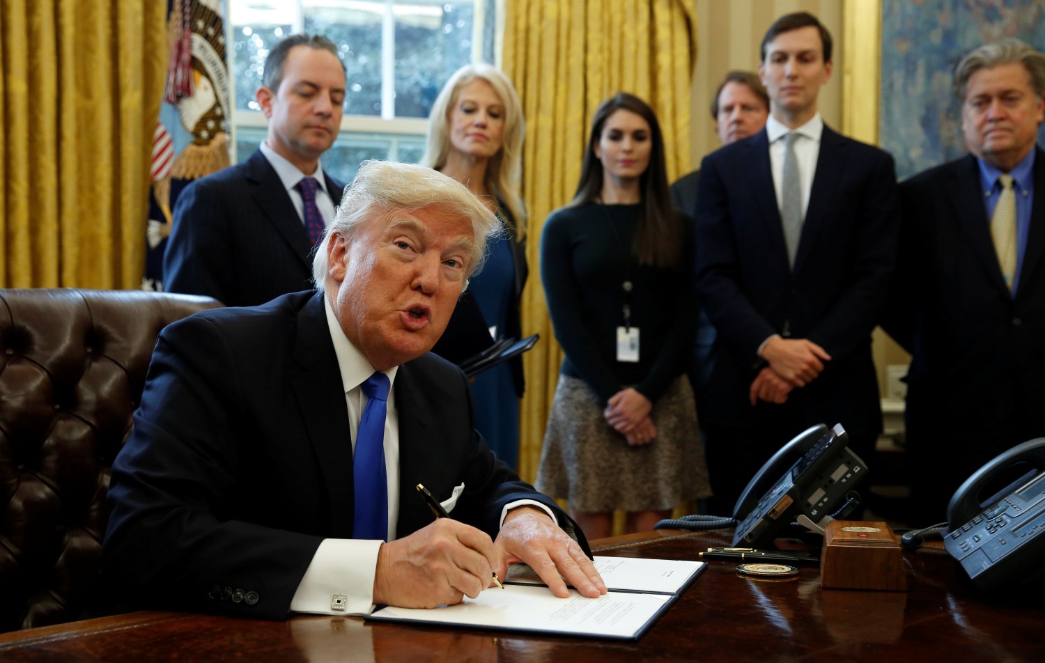 U.S. President Donald Trump looks up while signing an executive order