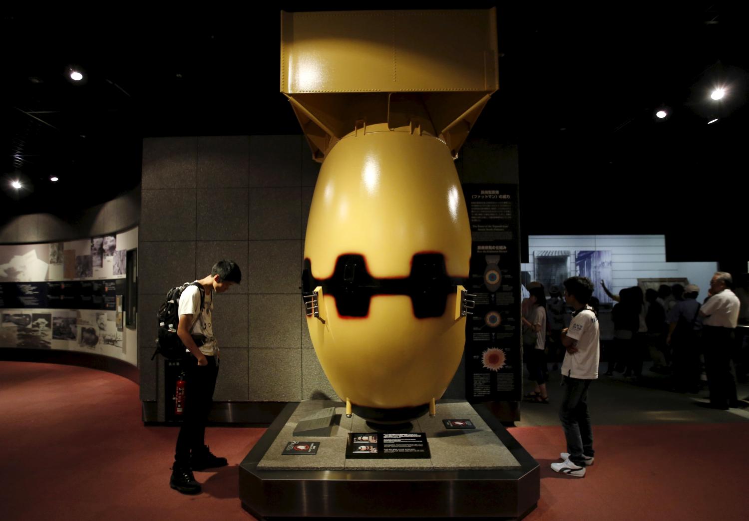 Visitors look at a mock Nagasaki-type atomic bomb named "Fat Man"