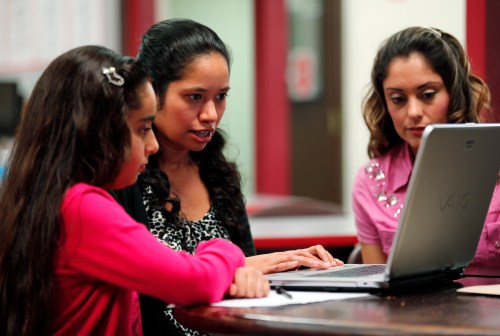 Villanueva and her 11-year-old daughter Laritza receive help on their charter school application from Barrio Logan College Institute counselor Pena in San Diego, California