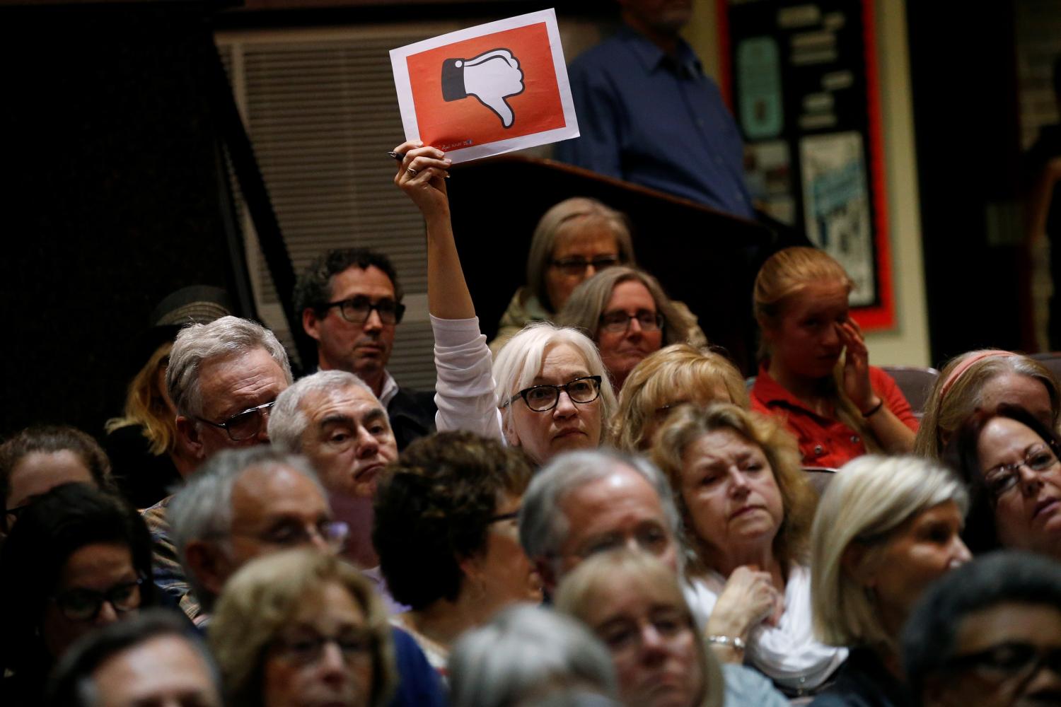 A voter holds up a sign during a town hall meeting with constituents by U.S. Representative Leonard Lance (R-NJ) in Cranford, New Jersey, U.S., May 30, 2017. REUTERS/Mike Segar - RTX38ALZ