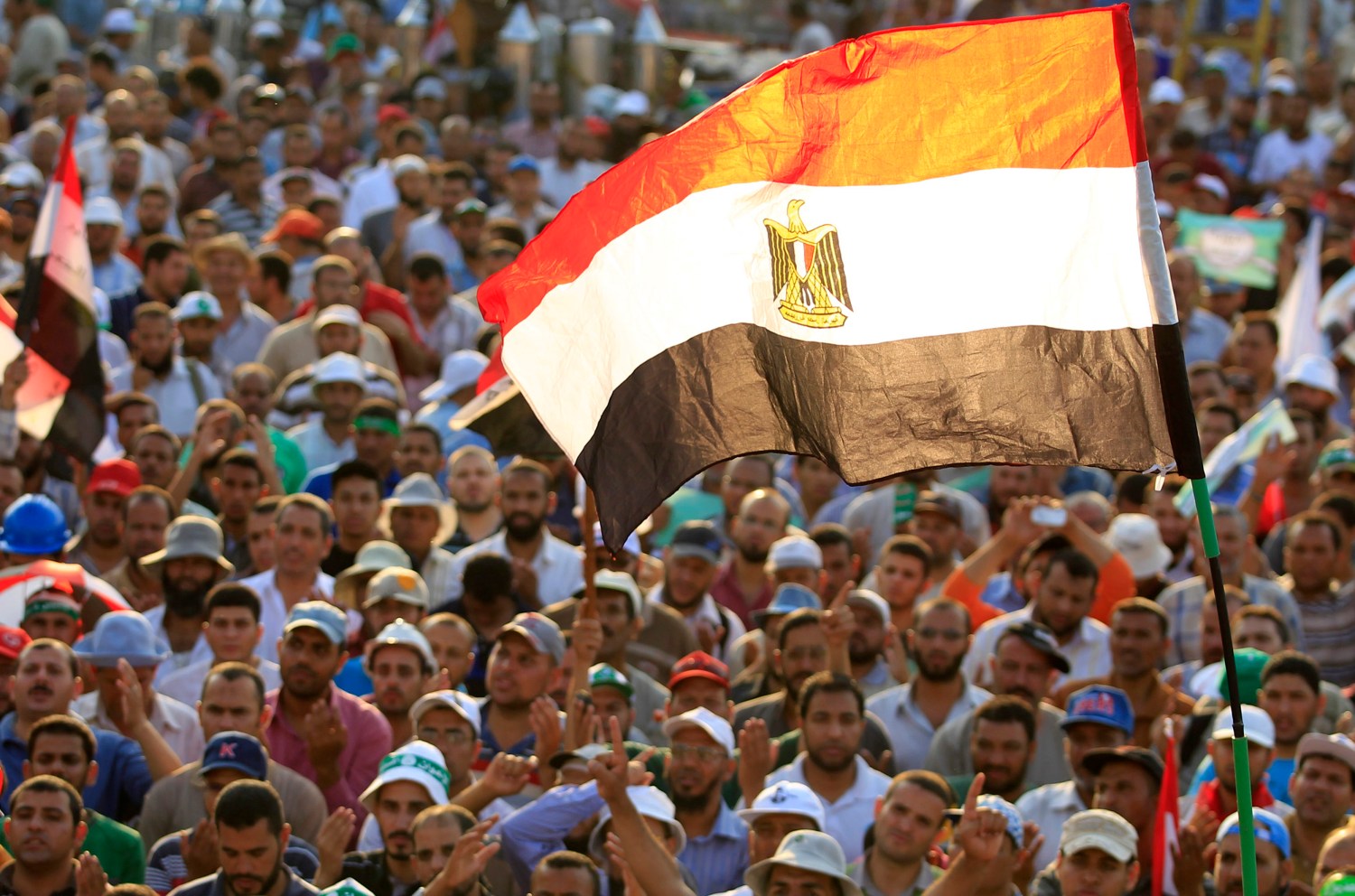 Members of the Muslim Brotherhood and supporters of Egyptian President Mohamed Mursi shout slogans and waves an Egyptian flag during a protest around the Raba El-Adwyia mosque square in Nasr City, in the suburb of Cairo June 29, 2013. Mass demonstrations across Egypt on Sunday may determine its future, two and half years after people power toppled a dictator they called Pharaoh and ushered in a democracy crippled by bitter divisions. The protesters' goal again is to unseat a president, this time their first freely elected leader, the Islamist Mursi. Liberal leaders say nearly half the voting population - 22 million people - have signed a petition calling for change. REUTERS/Mohamed Abd El Ghany (EGYPT - Tags: POLITICS CIVIL UNREST) - RTX116HI