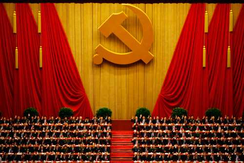 A general view shows delegates raising their hands as they take a vote at the closing session of the 18th National Congress of the Communist Party of China at the Great Hall of the People in Beijing November 14, 2012. REUTERS/Carlos Barria (CHINA - Tags: POLITICS) - RTR3ADEO