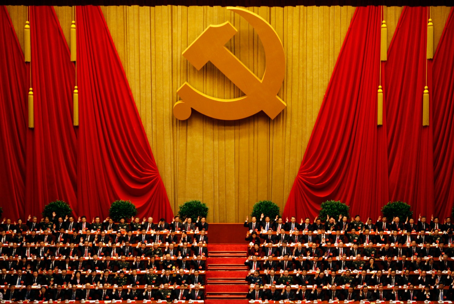 A general view shows delegates raising their hands as they take a vote at the closing session of the 18th National Congress of the Communist Party of China at the Great Hall of the People in Beijing November 14, 2012. REUTERS/Carlos Barria (CHINA - Tags: POLITICS) - RTR3ADEO