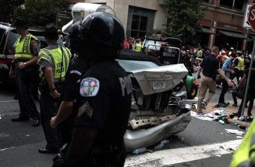 First responders stand by a car that was struck when a car drove through a group of counter protesters at a white nationalist/neo-Nazi rally in Charlottesville, Virginia.