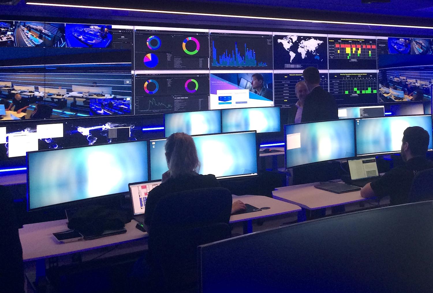 Employees can be seen in the Security Operation Centre for Telstra, Australia's biggest telecoms firm, which is used to monitor, detect and respond to security incidents, including cyber attacks, during a media event in central Sydney, Australia, August 24, 2017. REUTERS/Tom Westbrook - RTS1D3F6