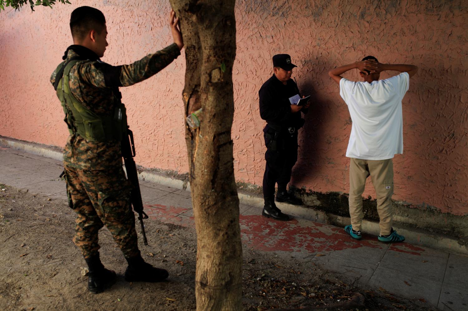 A policeman interrogates a suspected gang member prior to a ceremony to declare their communities a peace zone at La Selva neighborhood in Ilopango, El Salvador, February 3, 2017. The man was later released. Inhabitants of southern Ilopango declared their neighborhoods as violence-free zones to lower homicide rates in one of the most violent areas of El Salvador. REUTERS/Jose Cabezas - RTX2ZJRF
