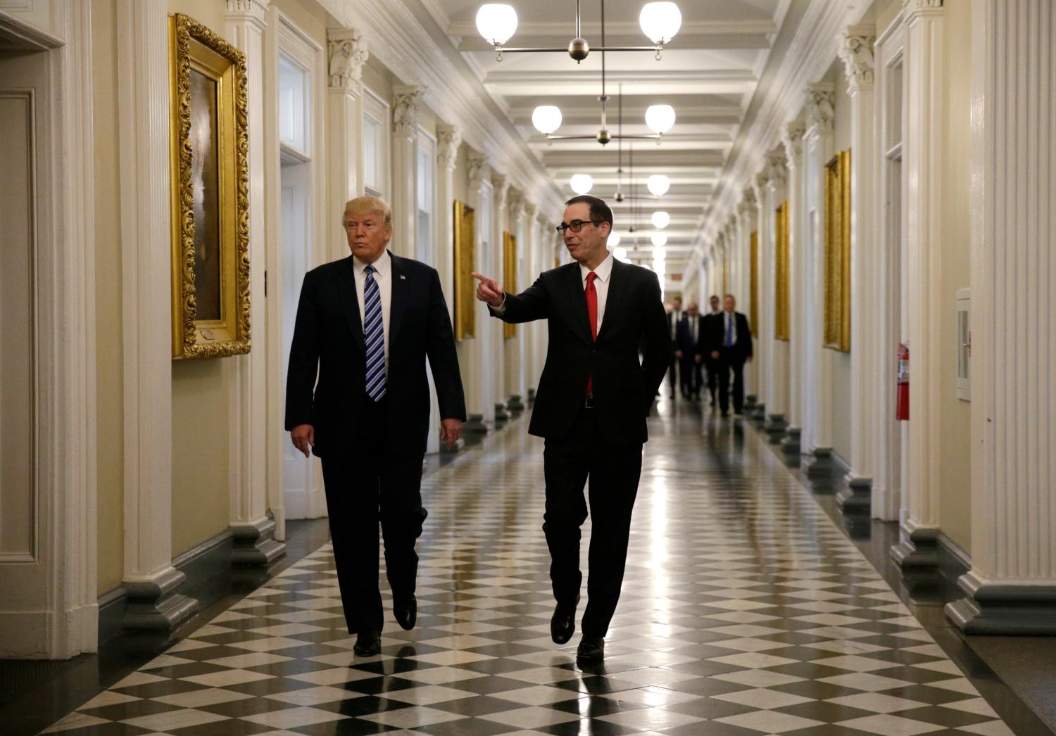 U.S. President Donald Trump (L) arrives with Treasury Secretary Steven Mnuchin prior to signing financial services executive orders at the Treasury Department in Washington.