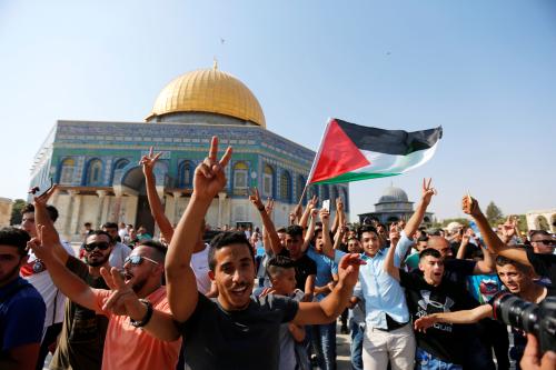 The Dome of the Rock is seen in the background as a man waves a Palestinian flag upon entering the compound known to Muslims as Noble Sanctuary and to Jews as Temple Mount, after Israel removed all security measures it had installed at the compound, in Jerusalem's Old City July 27, 2017. REUTERS/Muammar Awad