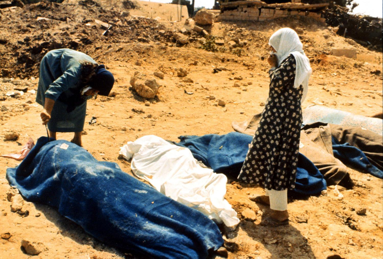 Two women inspect the bodies of the Sabra and Shatila massacre in this