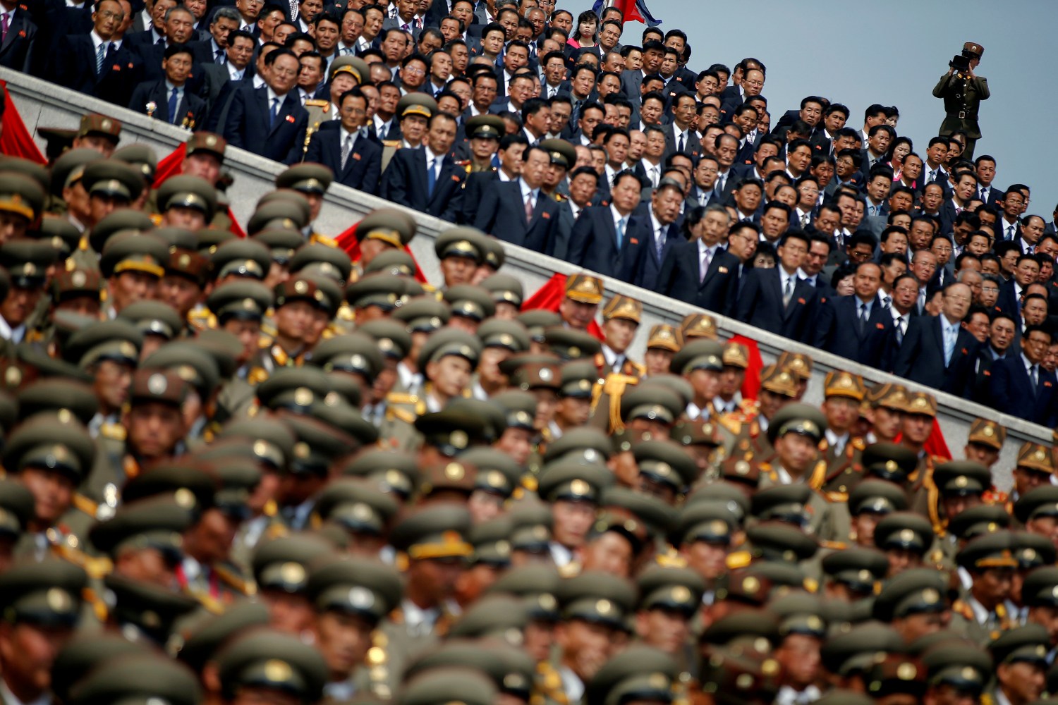 A soldier films North Korean soldiers, officers and high ranking officials attending a military parade marking the 105th birth anniversary of country's founding father Kim Il Sung in Pyongyang, North Korea, April 15, 2017. The parade is focused on a special balcony building from which Kim Jong Un watches proceedings. From there, one can see the tanks roll past and thousands of people working as human pixels to create large propaganda slogans using colourful placards and plastic flowers. The exposed seating area is divided into two. Party and military officials sit at stage right. Foreign diplomats and special guests sit at stage left. Journalists stand a few metres in front of them at ground level, beside the main parade route. REUTERS/Damir Sagolj TPX IMAGES OF THE DAY SEARCH "PARADE WID" FOR THIS STORY. SEARCH "WIDER IMAGE" FOR ALL STORIES. - RTS12G3Z