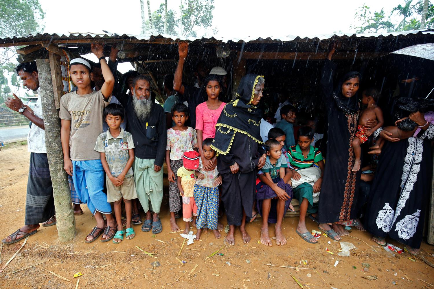 New Rohingya refugees take shelter during rain as they arrive near the Kutupalang makeshift Refugee Camp, in Coxs Bazar, Bangladesh, August 29, 2017. REUTERS/Mohammad Ponir Hossain - RTX3DT4E