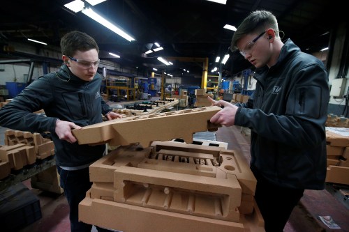 Apprentices Ryan Hickman (R) and Tom Tarr work with a sand mould of a car engine ready for casting at GW cast in Bridgnorth
