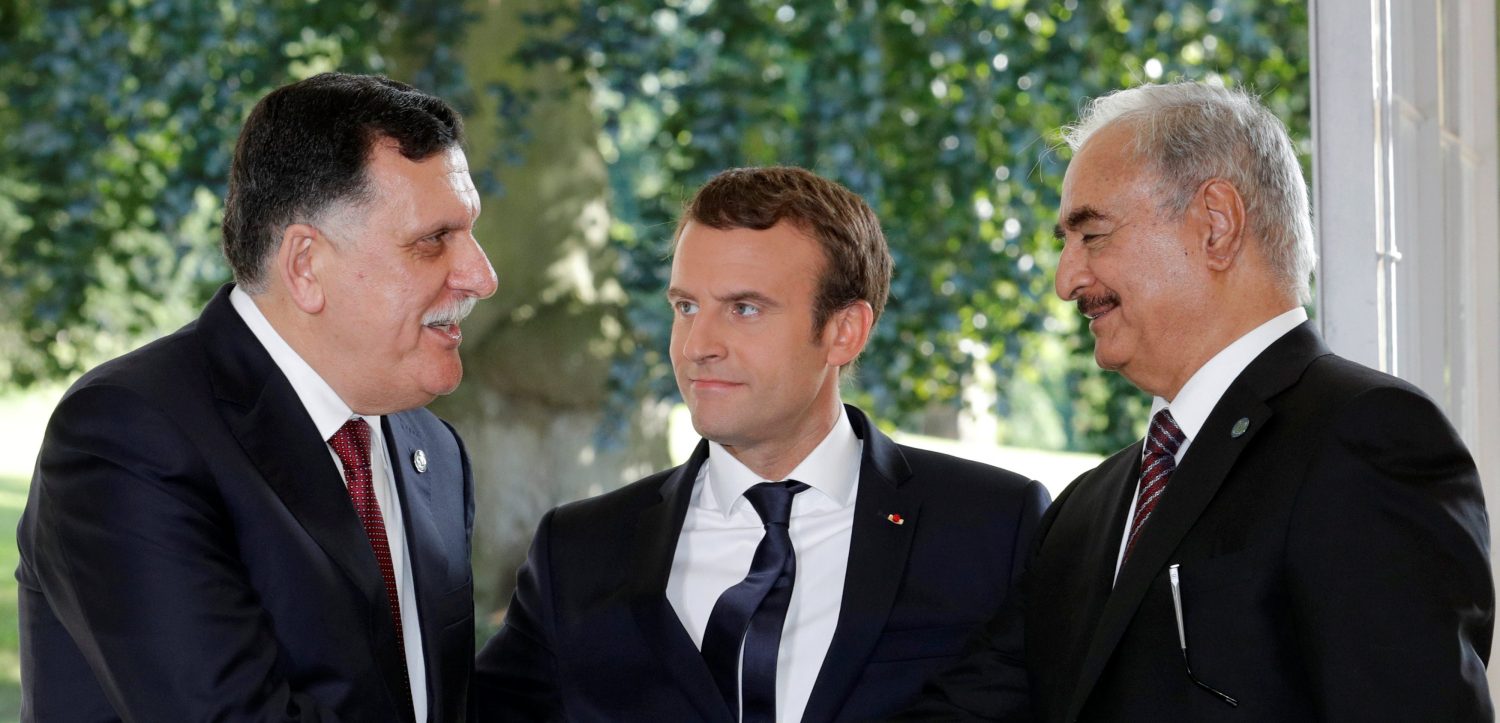 French President Emmanuel Macron stands between Libyan Prime Minister Fayez al-Sarraj (L), and General Khalifa Haftar (R), commander in the Libyan National Army (LNA), who shake hands after talks over a political deal to help end Libyas crisis in La Celle-Saint-Cloud near Paris, France, July 25, 2017. REUTERS/Philippe Wojazer TPX IMAGES OF THE DAY - RTX3CVLX