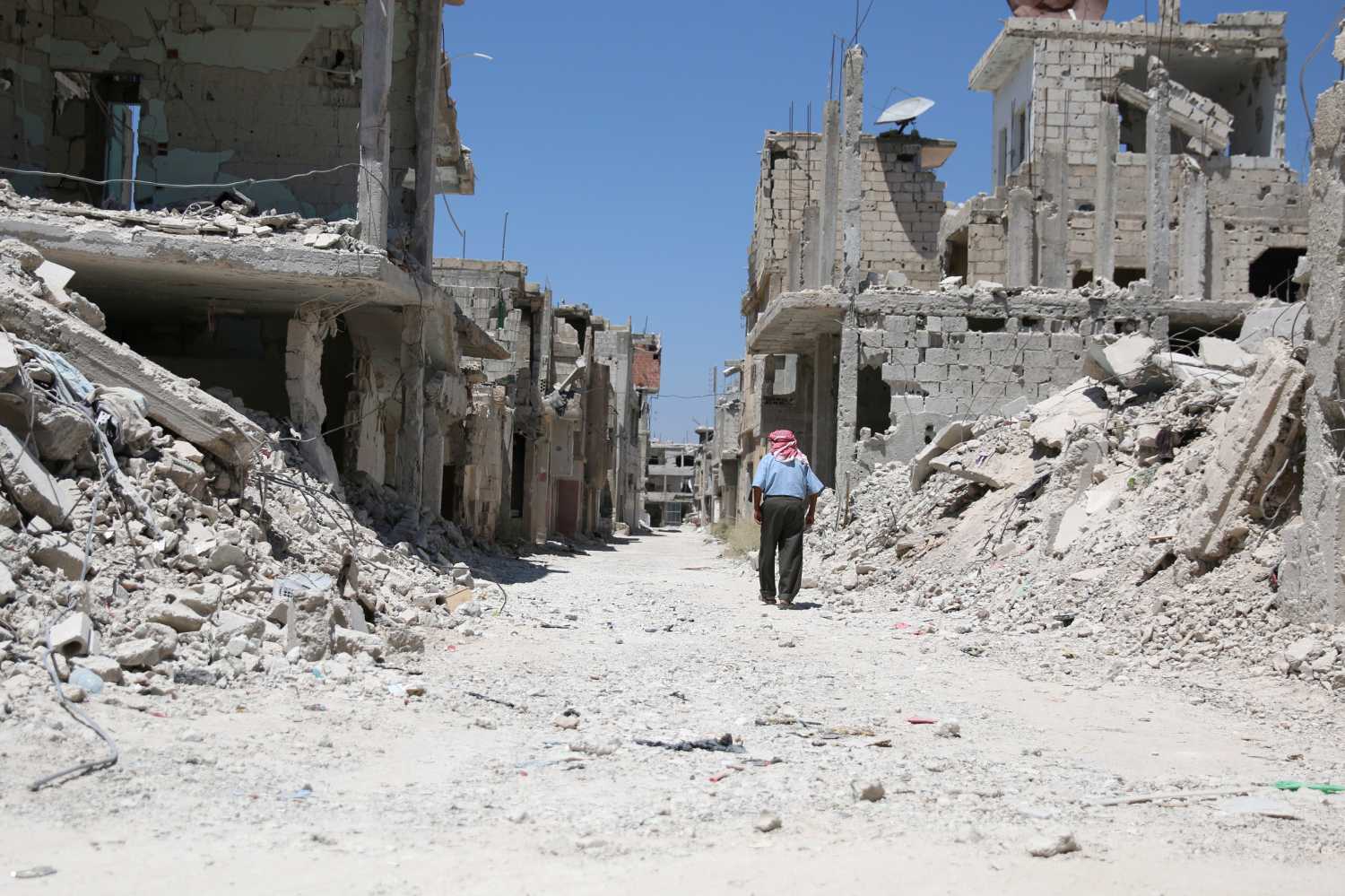 A man walks inside a former Palestinian refugee camp in a rebel-held part of the southern city of Deraa, Syria August 6, 2017. REUTERS/Alaa al-Faqir - RTS1AMVG