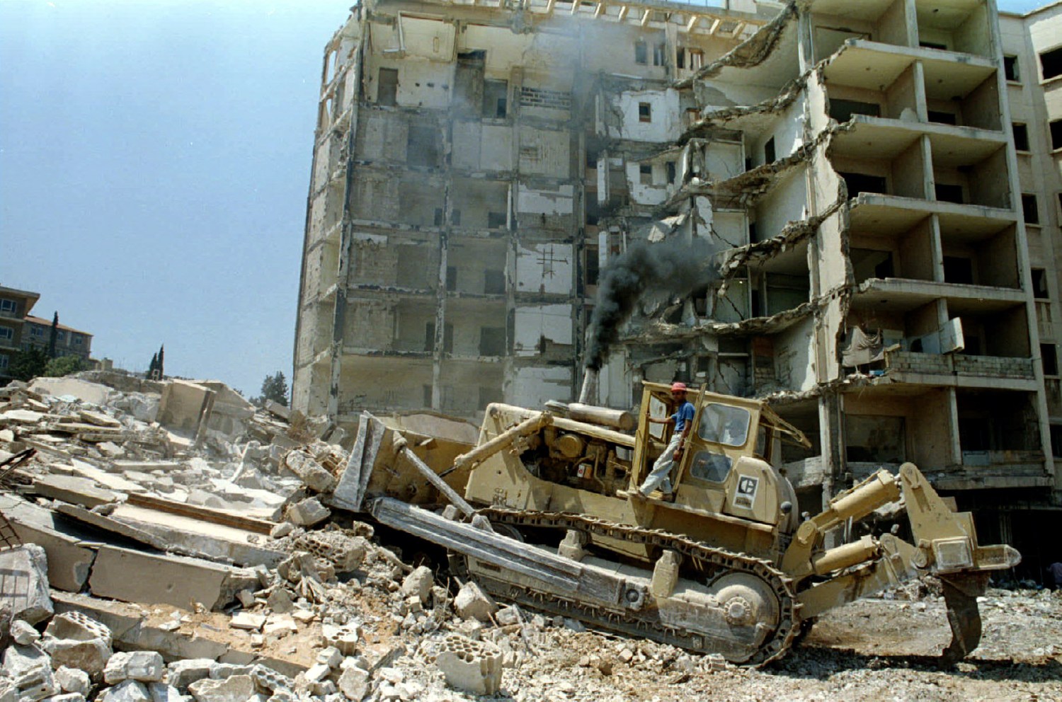 A bulldozer demolishes August 7 the bombed out building of the American embassy in Beirut. The embassy, in the mainly-moslem sector, was wrecked in a suicide attack by a pro-Iranian militant that Killed 17 Americans in 1983 - RTXFAWK