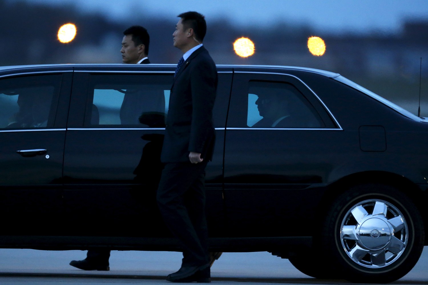 Security agents walk alongside Chinese President Xi Jinping's (silhouetted, 2nd R in window) car as he arrives to attend the upcoming Nuclear Security Summit meetings in Washington, on the tarmac at Joint Base Andrews, Maryland March 30, 2016. REUTERS/Jonathan Ernst TPX IMAGES OF THE DAY - RTSCX2F