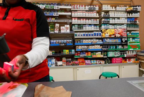 Cigarettes are displayed behind the counter of a convenient store.