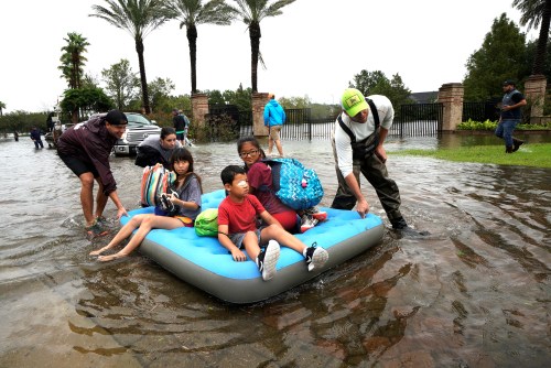 A family is evacuated on an air mattress from the Hurricane Harvey floodwaters in Houston